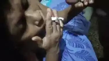 Older bitch smokin' cigarette engulfing dick at the same time